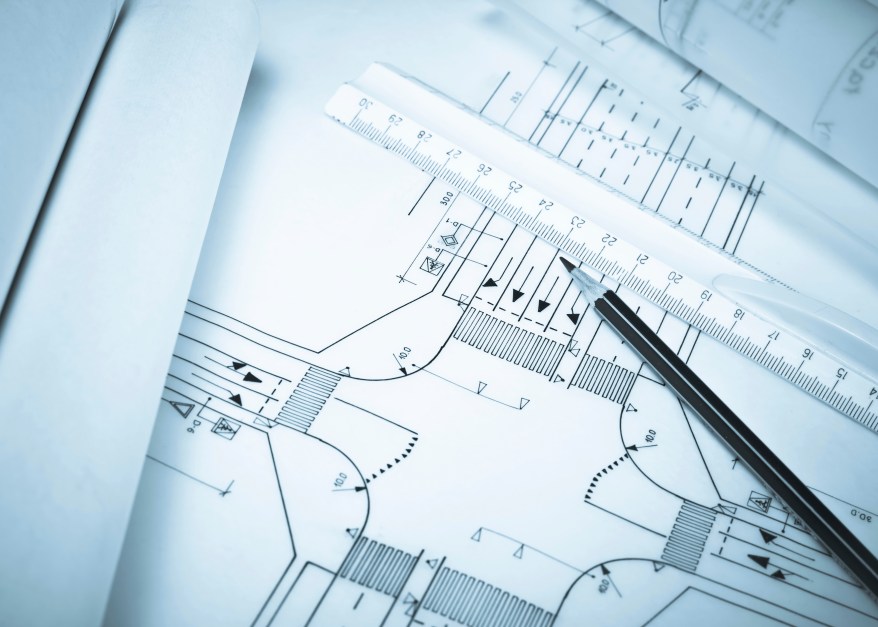 Rule and pencil against road plan. Blue tone. Shallow DOF.